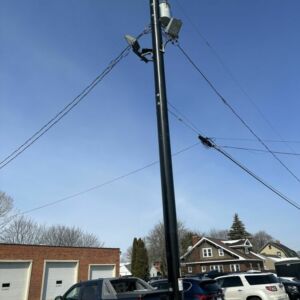 Trident multi-layer pole in neighborhood surrounded by cars