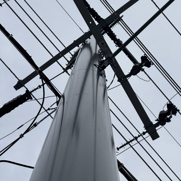 Looking up at a Trident utility pole supporting a host of utility lines